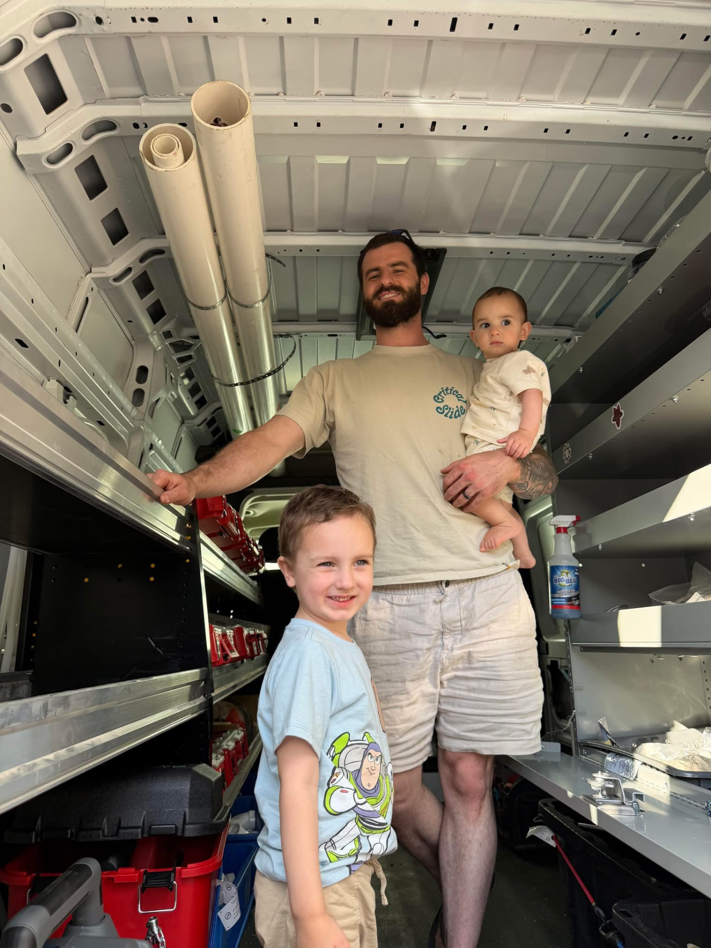 The owner and his kids inside the OctoFlow work van, surrounded by stocked shelves of tools